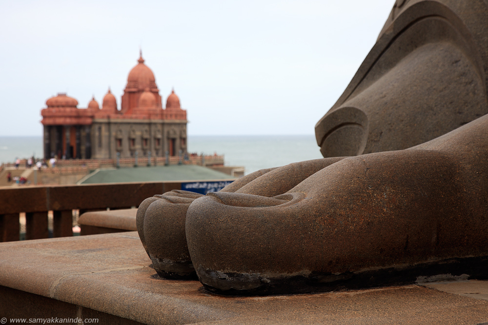 The feet fingers of Thiruvalluvar statue and vivekanada rock memorial in background.